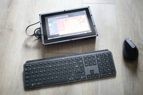 Un écran sans fil, un clavier sans fil et un souris sans fil posés par terre. L’écran affiche le jeu OpenRA sur Raspbian OS.