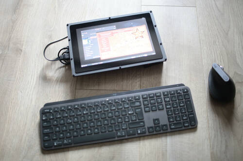 A wireless keyboard, a wireless mouse and screen on a ground. The screen display OpenRA on Raspbian OS.